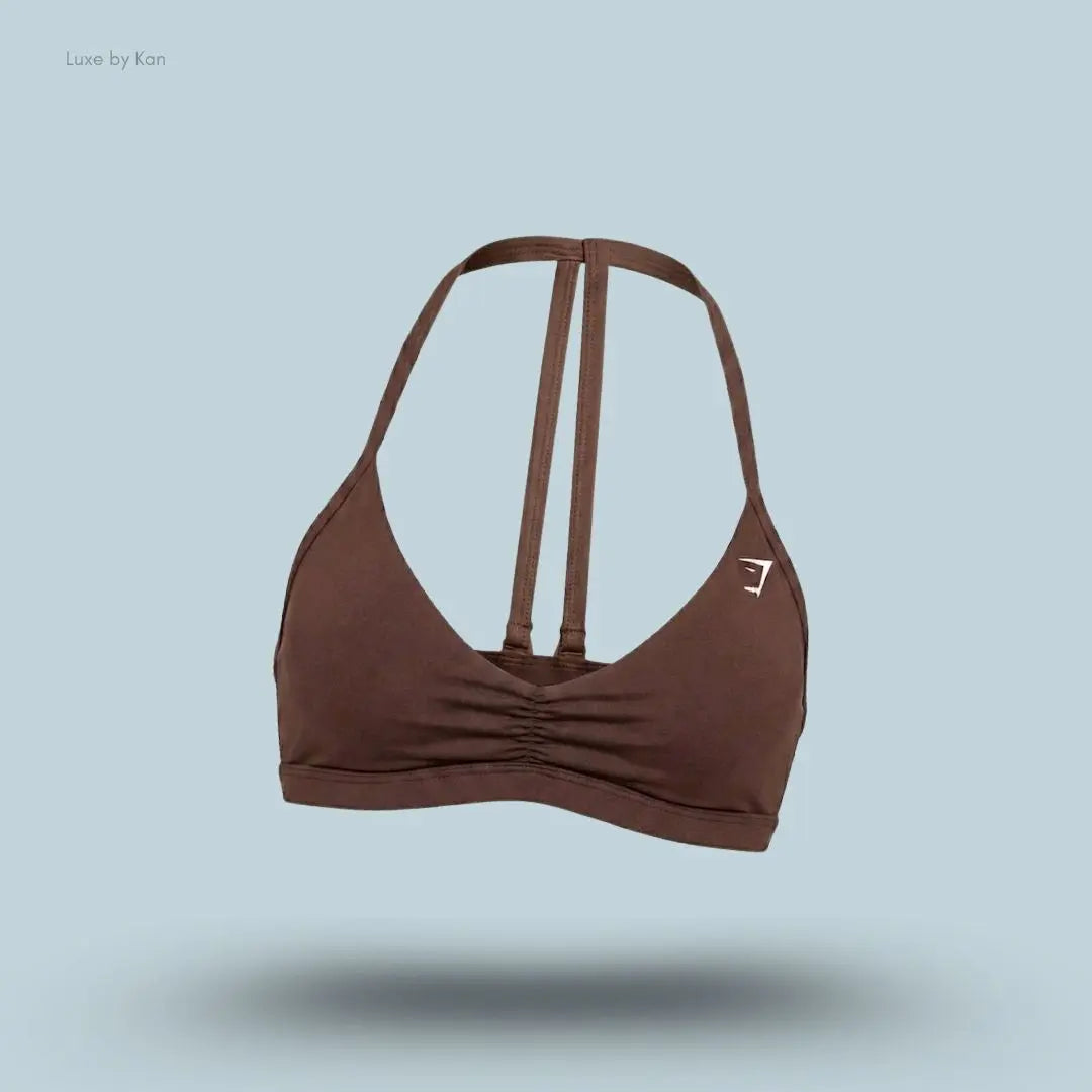 Gymshark Minimal Sports Bra 2.0 in Espresso Brown, flat lay on light blue background