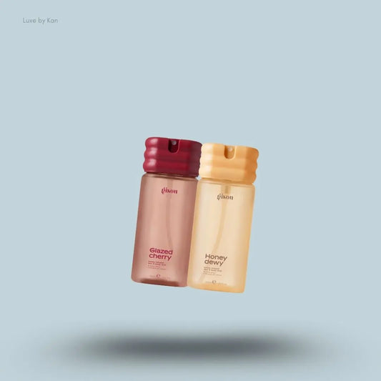 Gisou Honey Infused Hair & Body Mist Duo in Honey Dewy and Glazed Cherry, flat lay on light blue background