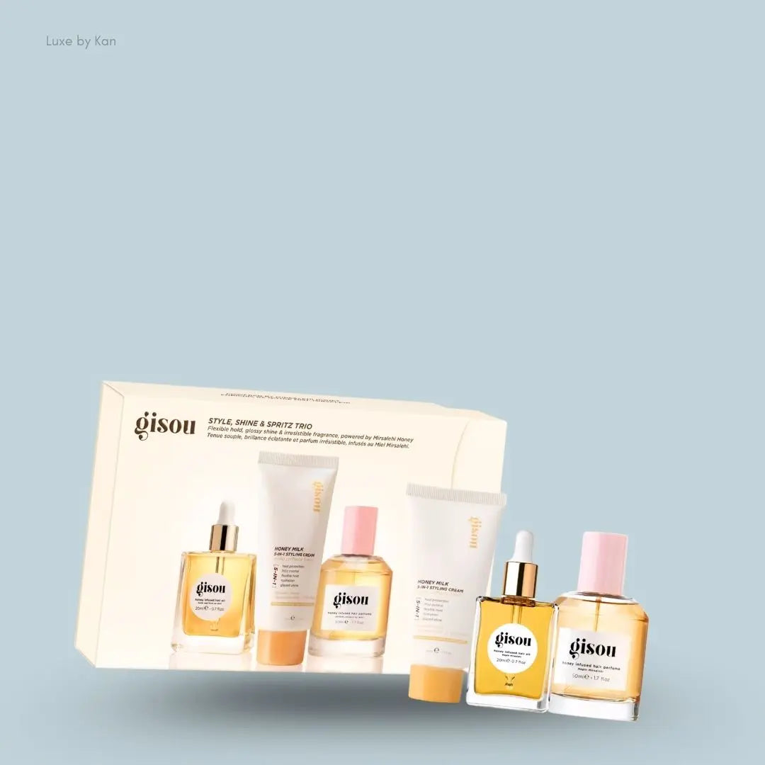 Gisou Style, Shine & Spritz Trio set with styling cream, hair oil and hair perfume, flat lay on light blue background