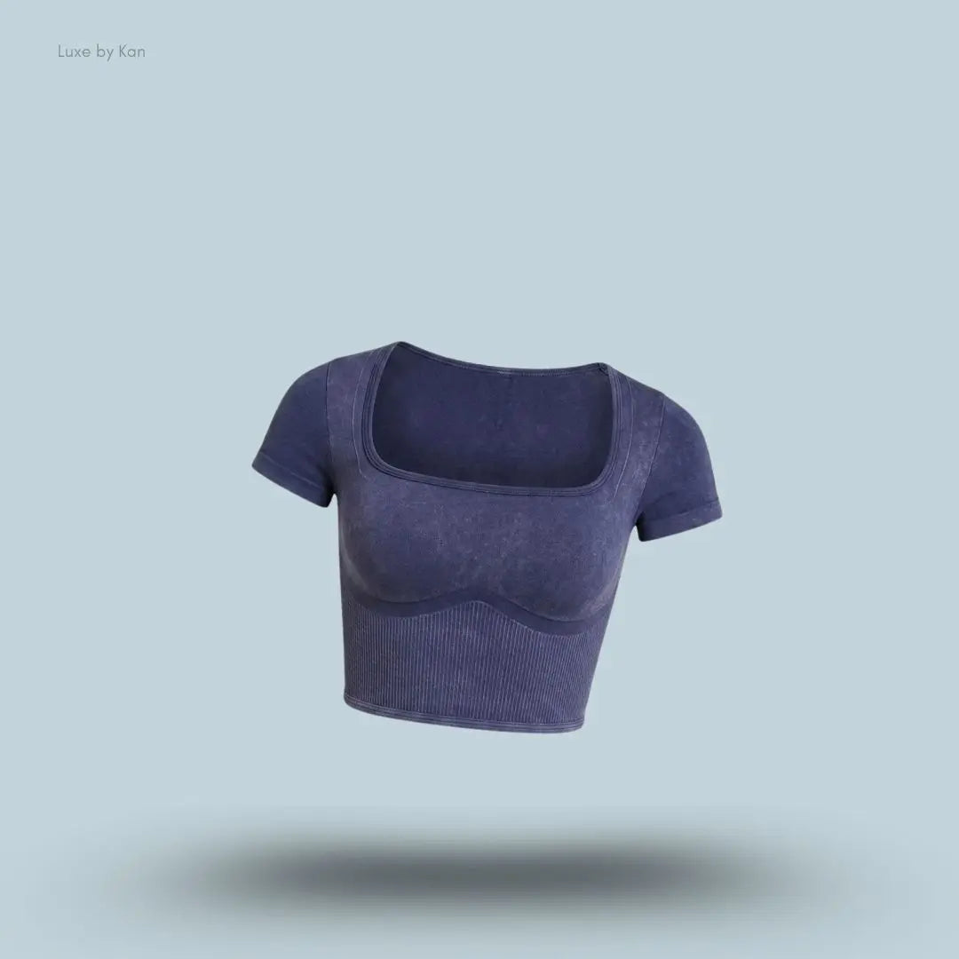 Gymshark x Bratz Crop Top in indigo purple displayed on a blue background with a body-fit cropped design