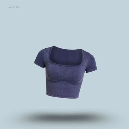 Gymshark x Bratz Crop Top in indigo purple displayed on a blue background with a body-fit cropped design