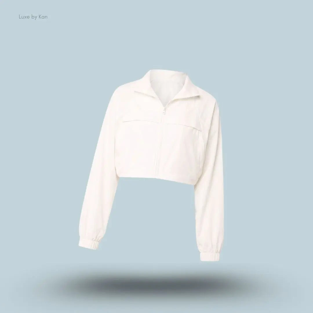 Alo Cropped Playmaker Jacket in Ivory, flat lay on light blue background