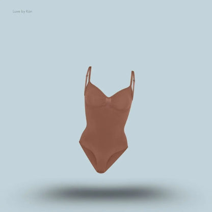 SKIMS Seamless Sculpt Brief Bodysuit in a brown shade, front view with adjustable shoulder straps and seamless sculpting design on blue background