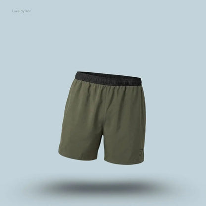 Gymshark Arrival Contrast Shorts in olive green displayed on a blue background with a slim-fit athletic shorts design
