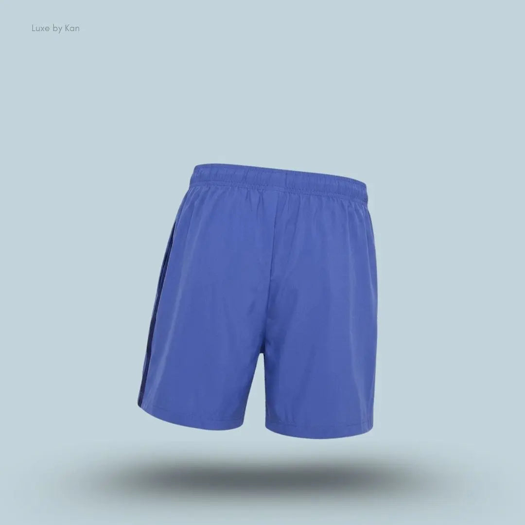 Gymshark Sport 5" Shorts men's slim-fit training shorts in blue with contrast side panels on a blue background back view