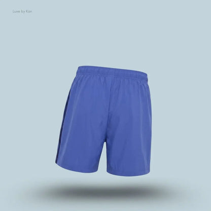 Gymshark Sport 5" Shorts men's slim-fit training shorts in blue with contrast side panels on a blue background back view