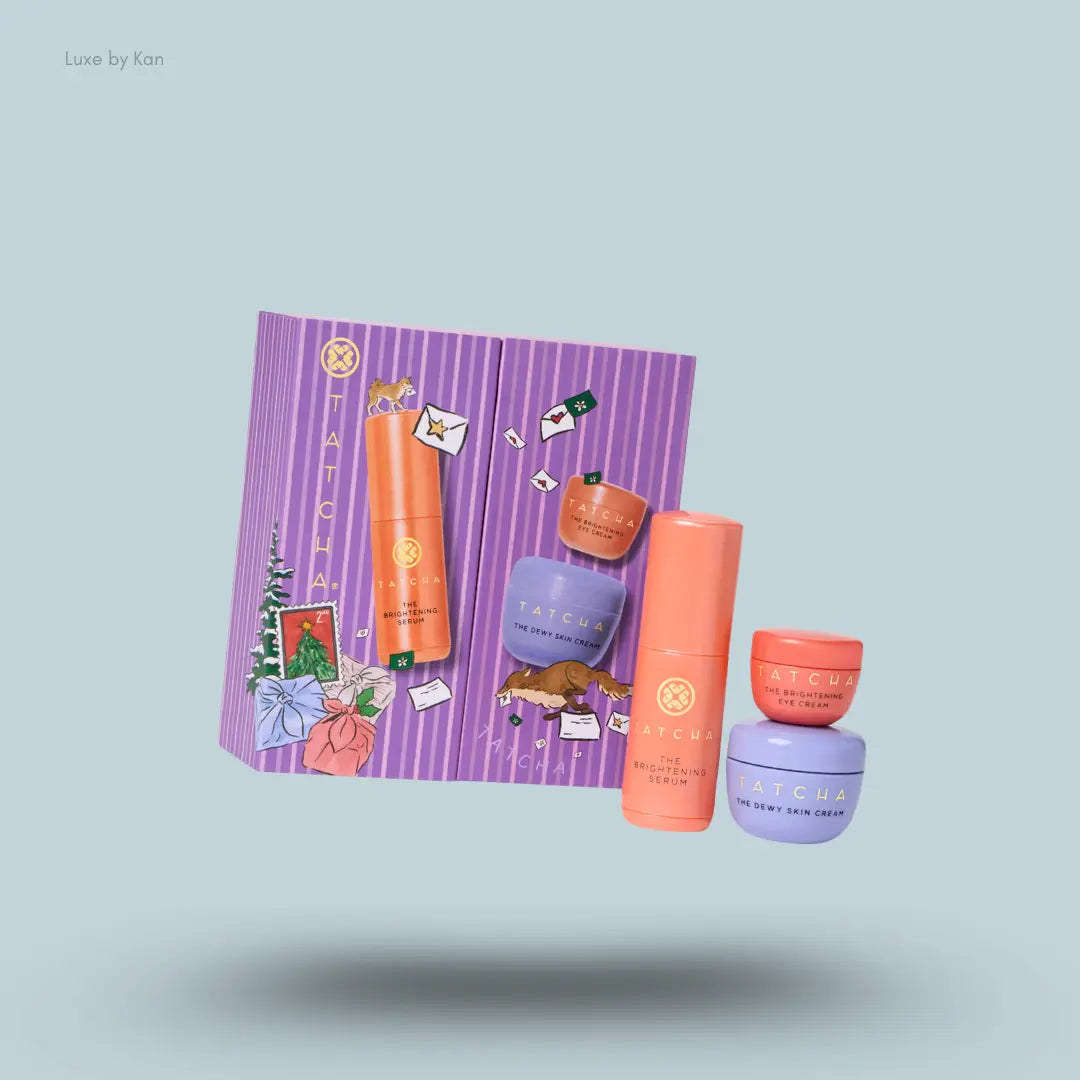 Tatcha Dewy & Bright Favorites Set three skincare products with purple festive gift box on blue background