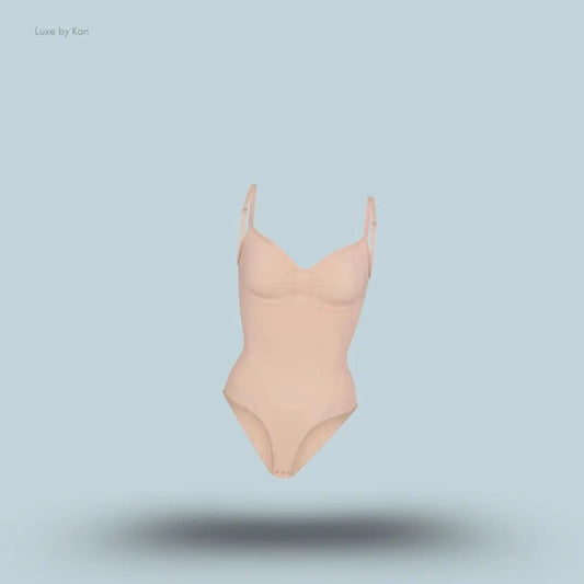 SKIMS Seamless Sculpt Brief Bodysuit in a nude shade, front view with adjustable shoulder straps and seamless sculpting design on blue background