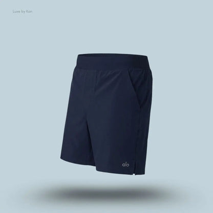 Alo 5 inch Repetition Short in Navy, flat lay on light blue background