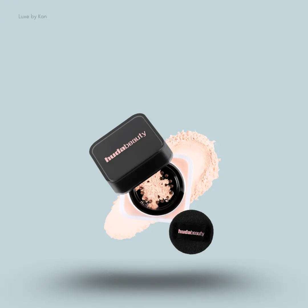 Huda Beauty Baby Bake Easy Bake Loose Powder Mini in Peach Pie, on light blue background