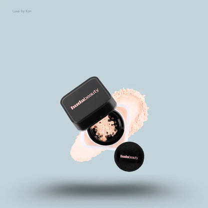 Huda Beauty Baby Bake Easy Bake Loose Powder Mini in Peach Pie, on light blue background