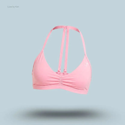 Gymshark Minimal Sports Bra 2.0 in Poise Pink, flat lay on light blue background