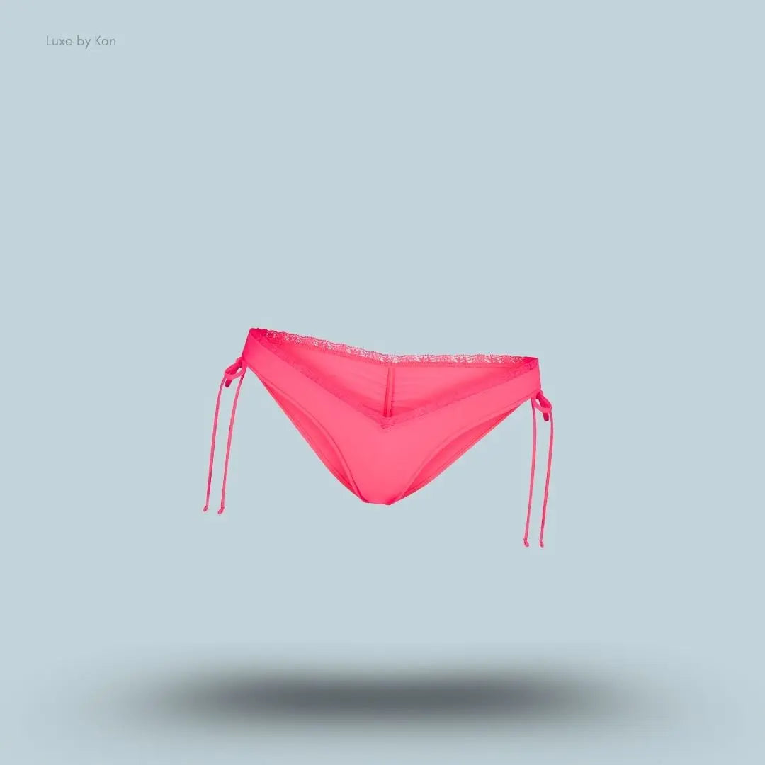 SKIMS Fits Everybody Lace Micro Tanga in Ultra Pink, flat lay on light blue background