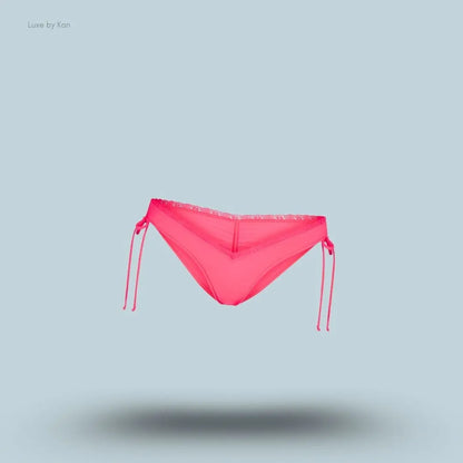 SKIMS Fits Everybody Lace Micro Tanga in Ultra Pink, flat lay on light blue background
