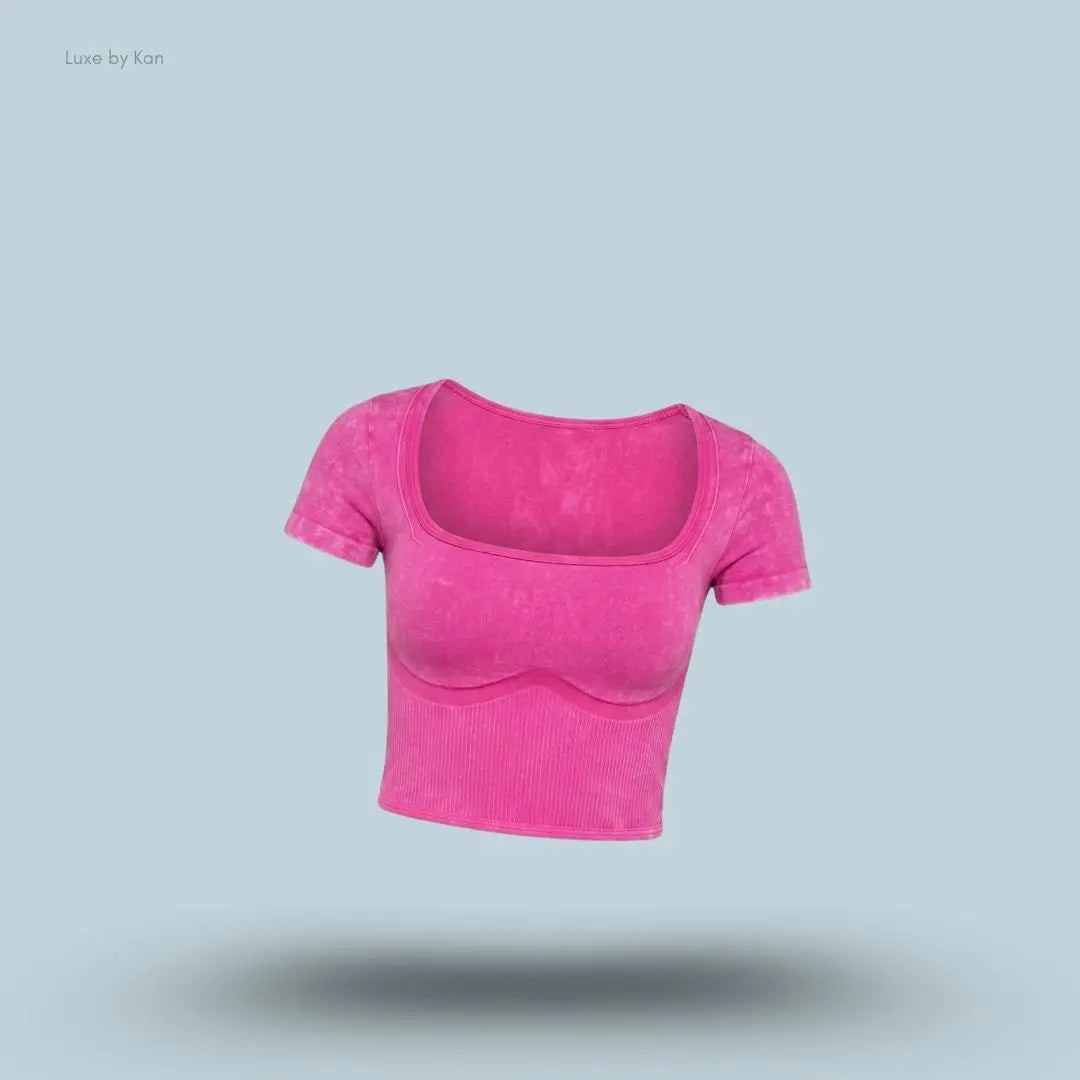 Gymshark x Bratz Crop Top in pink displayed on a blue background with a body-fit cropped design