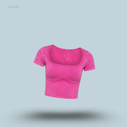 Gymshark x Bratz Crop Top in pink displayed on a blue background with a body-fit cropped design
