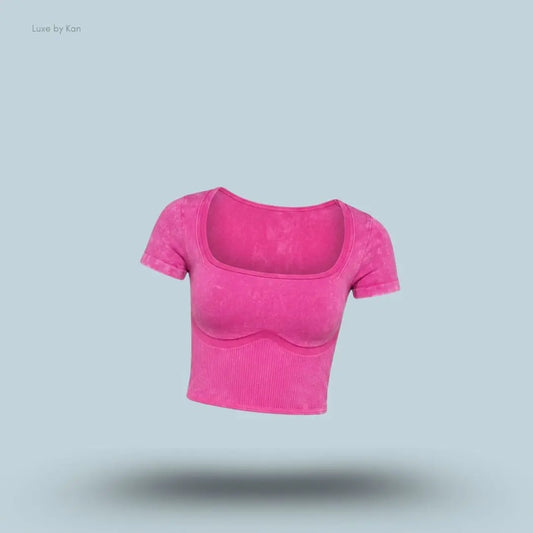 Gymshark x Bratz Crop Top in pink displayed on a blue background with a body-fit cropped design