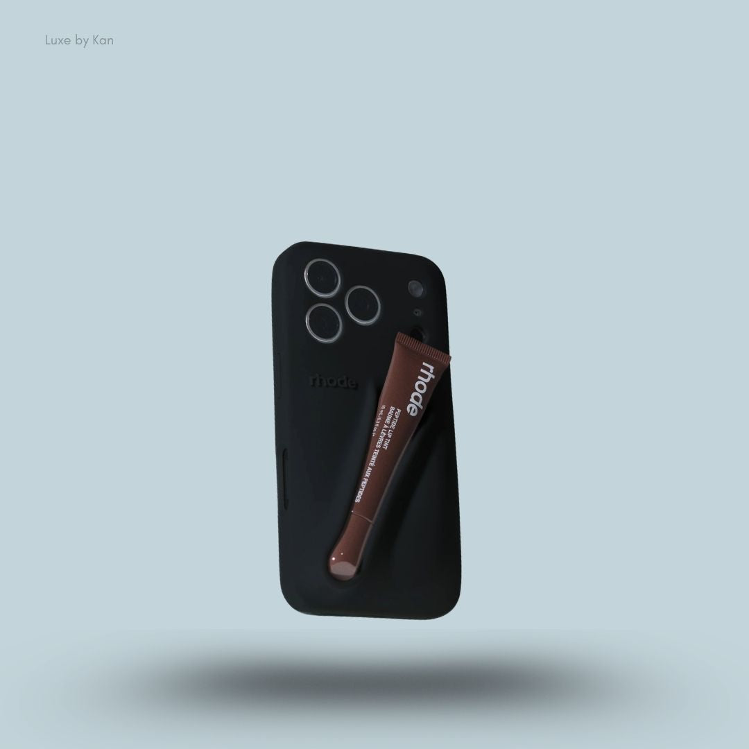 Rhode phone case in black against blue background; the word "rhode" embossed on the back, with loop for lip balm.