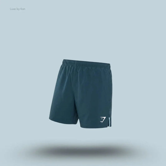 Gymshark Arrival Contrast Shorts in stealth blue displayed on a blue background with a slim-fit athletic shorts design