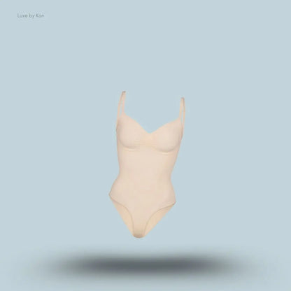 SKIMS Seamless Sculpt Brief Bodysuit in a nude shade, front view with adjustable shoulder straps and seamless sculpting design on blue background