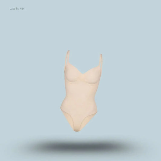 SKIMS Seamless Sculpt Brief Bodysuit in a nude shade, front view with adjustable shoulder straps and seamless sculpting design on blue background