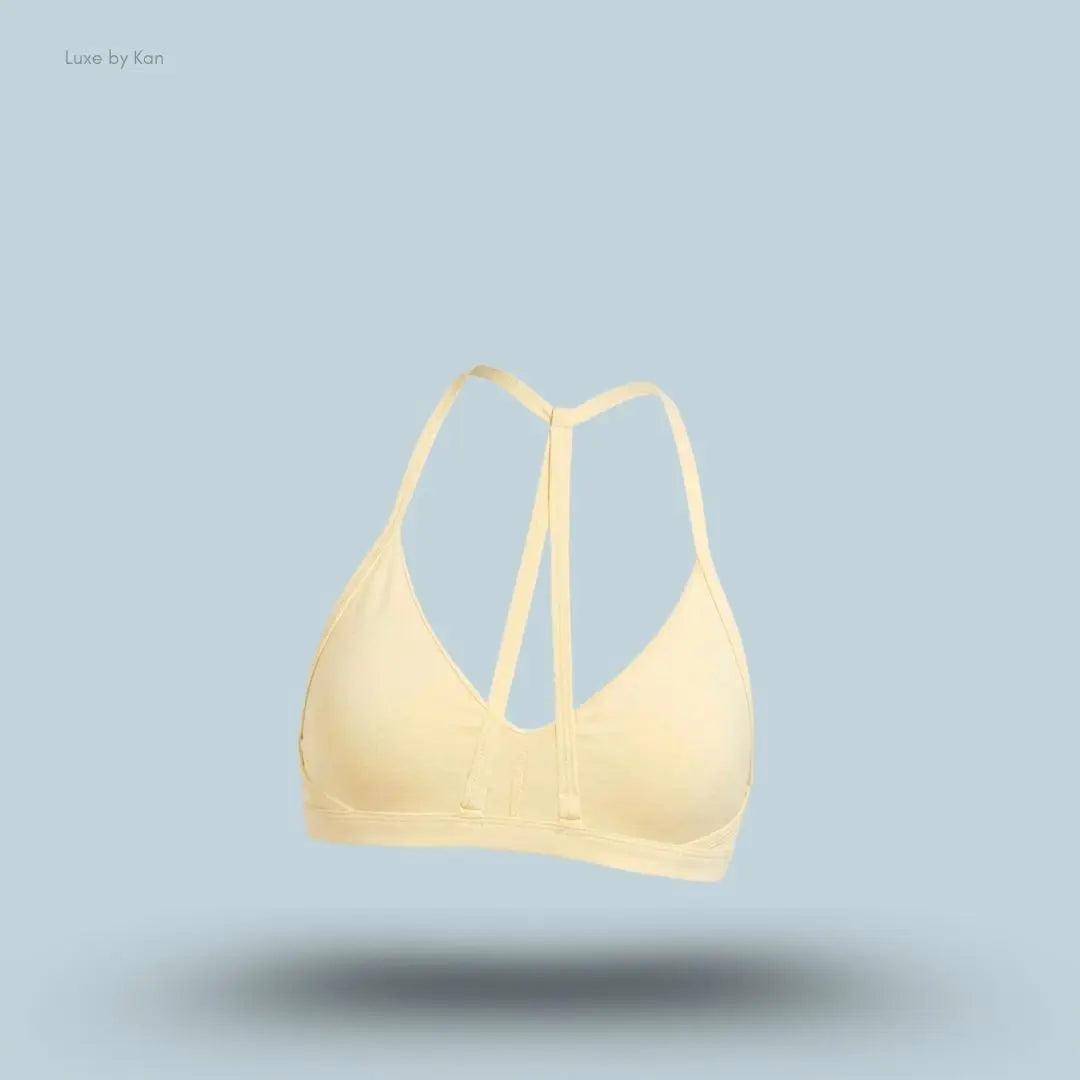 Gymshark Minimal Sports Bra 2.0 in Butter Yellow back view, flat lay on light blue background