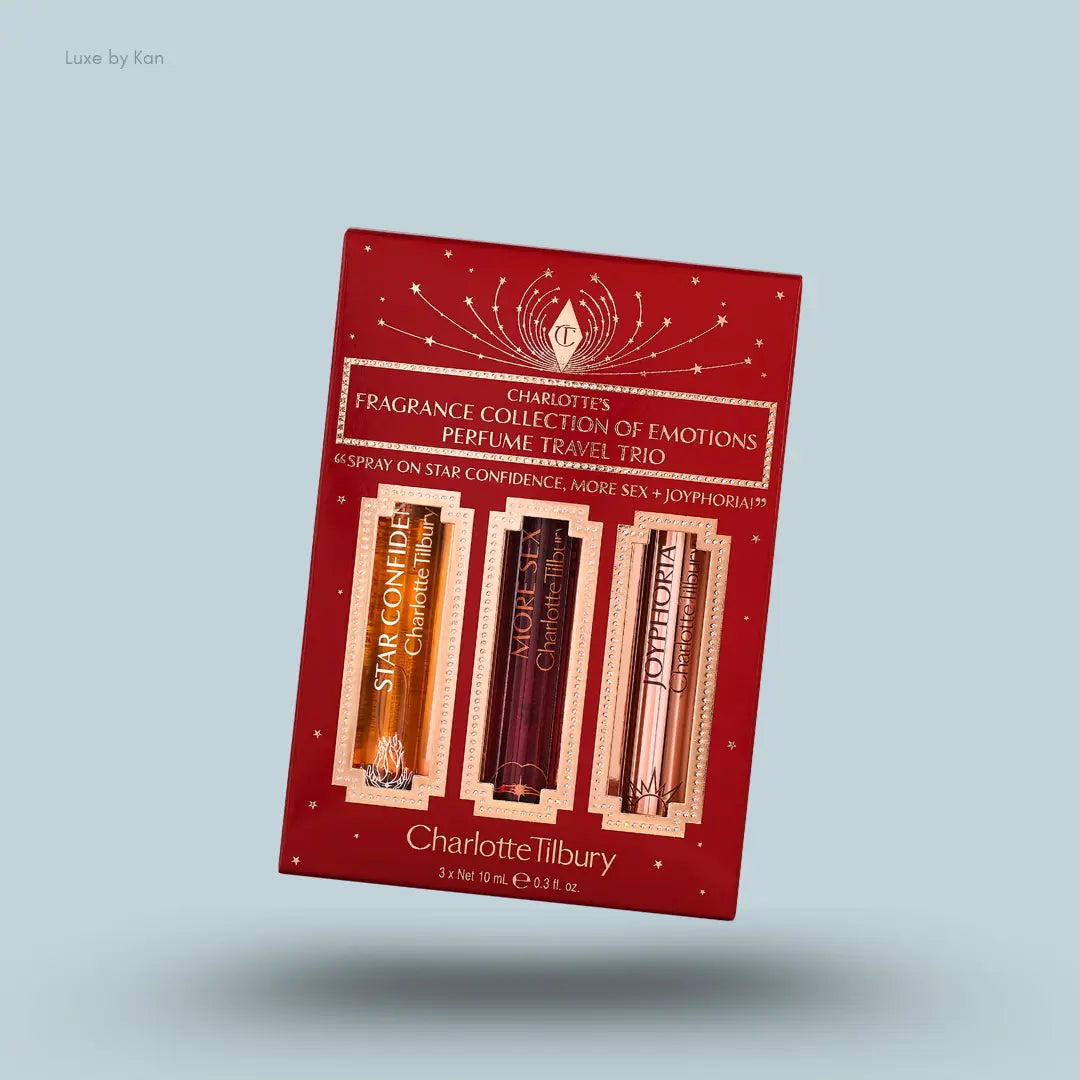 Charlotte Tilbury Charlotte’s Fragrance Collection of Emotions three fragrance bottles with packaging on blue background