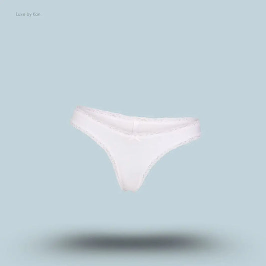 SKIMS Lightweight Cotton Lace Thong in Snow, flat lay on light blue background