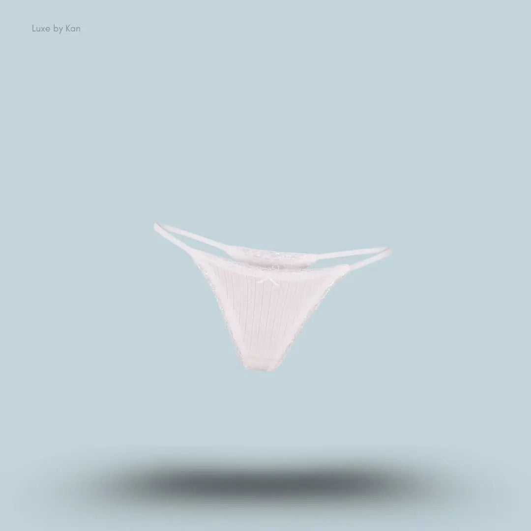 SKIMS Lightweight Cotton Pointelle Lace String Thong in Snow, flat lay on light blue background