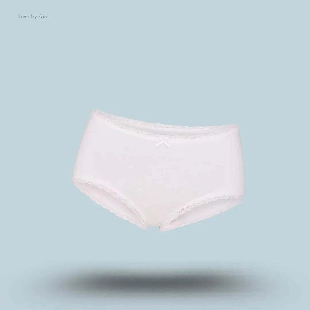 SKIMS Lightweight Cotton Lace Boy Short in Snow, flat lay on light blue background