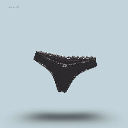 SKIMS Lightweight Cotton Lace Thong in Soot, flat lay on light blue background