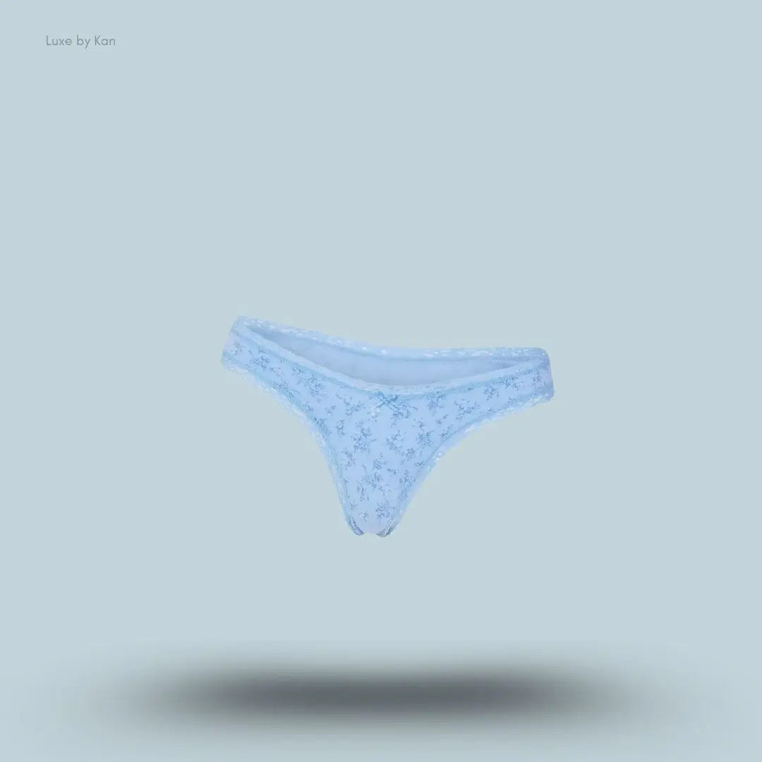 SKIMS Lightweight Cotton Lace Thong in Surf Dainty Floral Print, flat lay on light blue background
