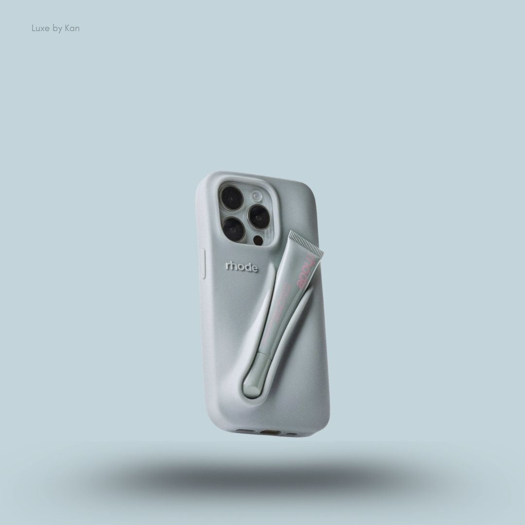 Rhode phone case in grey against blue background; the word "rhode" embossed on the back, with loop for lip balm.