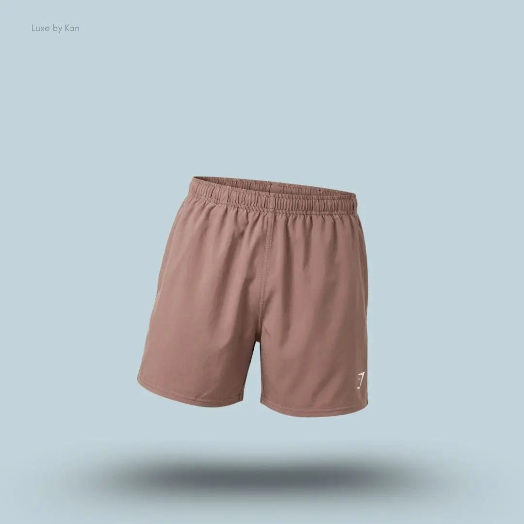 Gymshark Washed Pastels Shorts in brown displayed on a blue background with a relaxed athletic shorts design