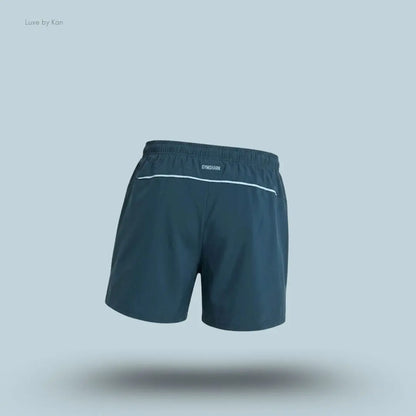 Gymshark Arrival Contrast Shorts in stealth blue displayed on a blue background with a slim-fit athletic shorts design back view
