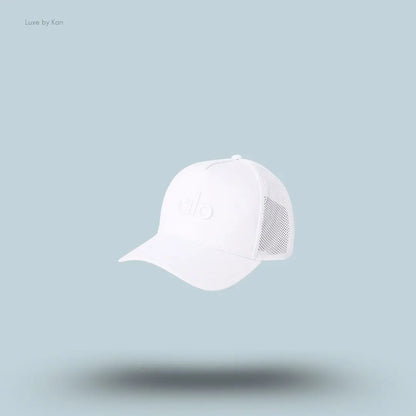 Alo District Trucker Hat in White, flat lay on light blue background