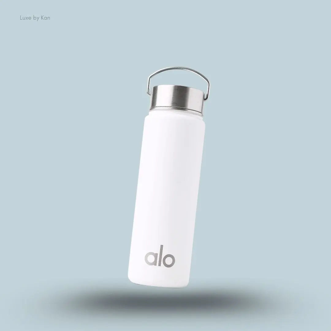 Alo Water Bottle in White, flat lay on light blue background