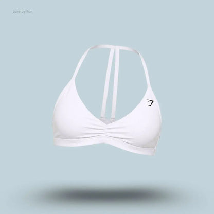 Gymshark Minimal Sports Bra 2.0 in White, flat lay on light blue background