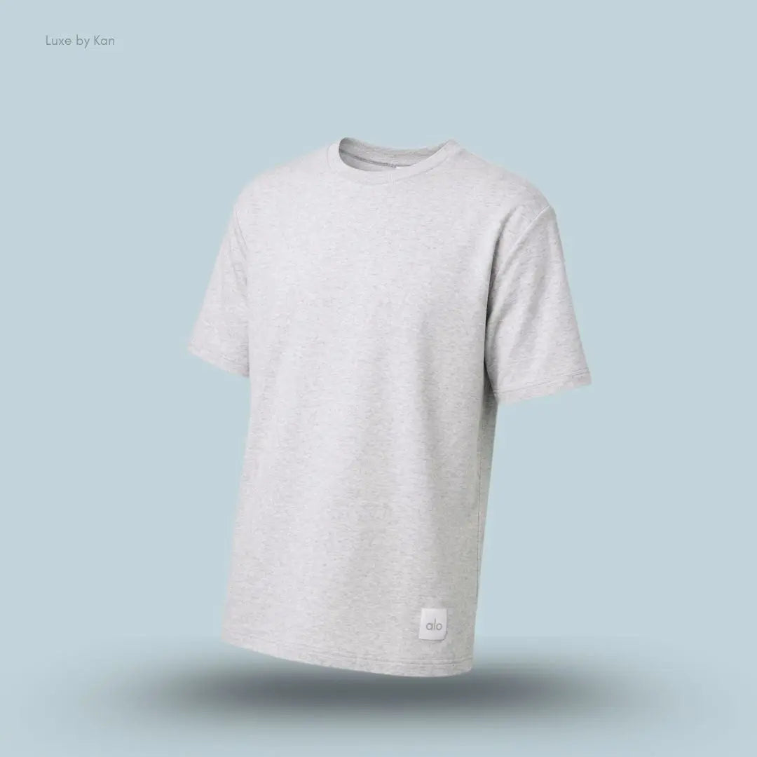Alo Double Take Short Sleeve in White Heather, flat lay on light blue background