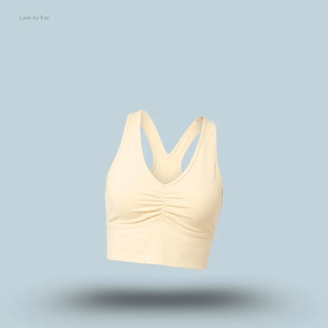 Alo Wild Thing Bra in Candlelight Yellow, flat lay on light blue background