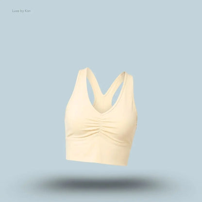 Alo Wild Thing Bra in Candlelight Yellow, flat lay on light blue background